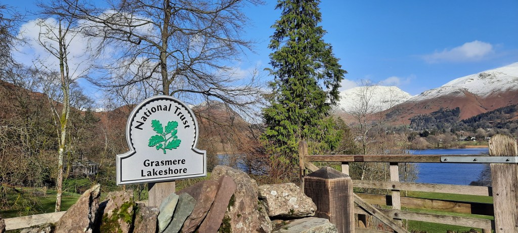By the entrance of the Coffin Trail, set against the backdrop of snowy mountains.